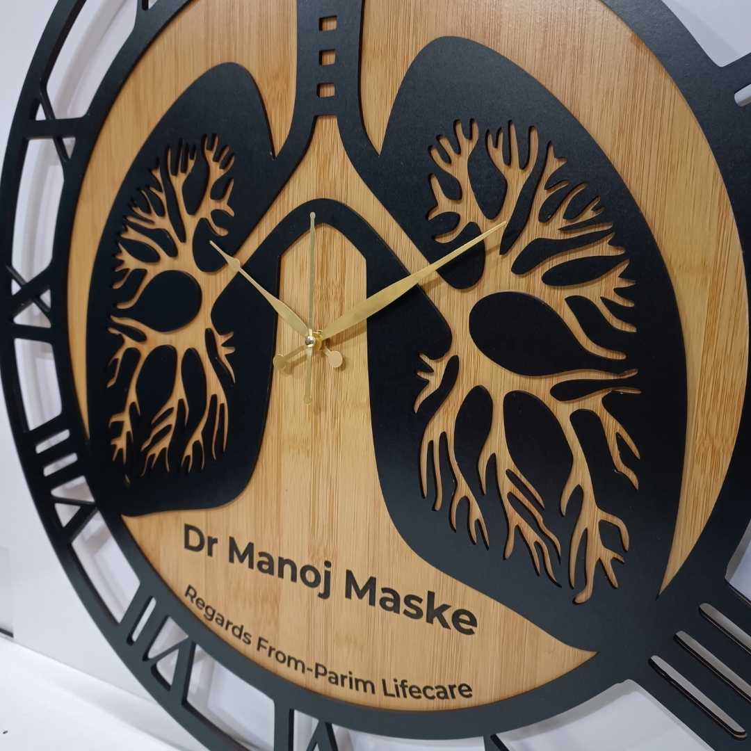 Wooden wall clock with lung design and engraved text on a white background