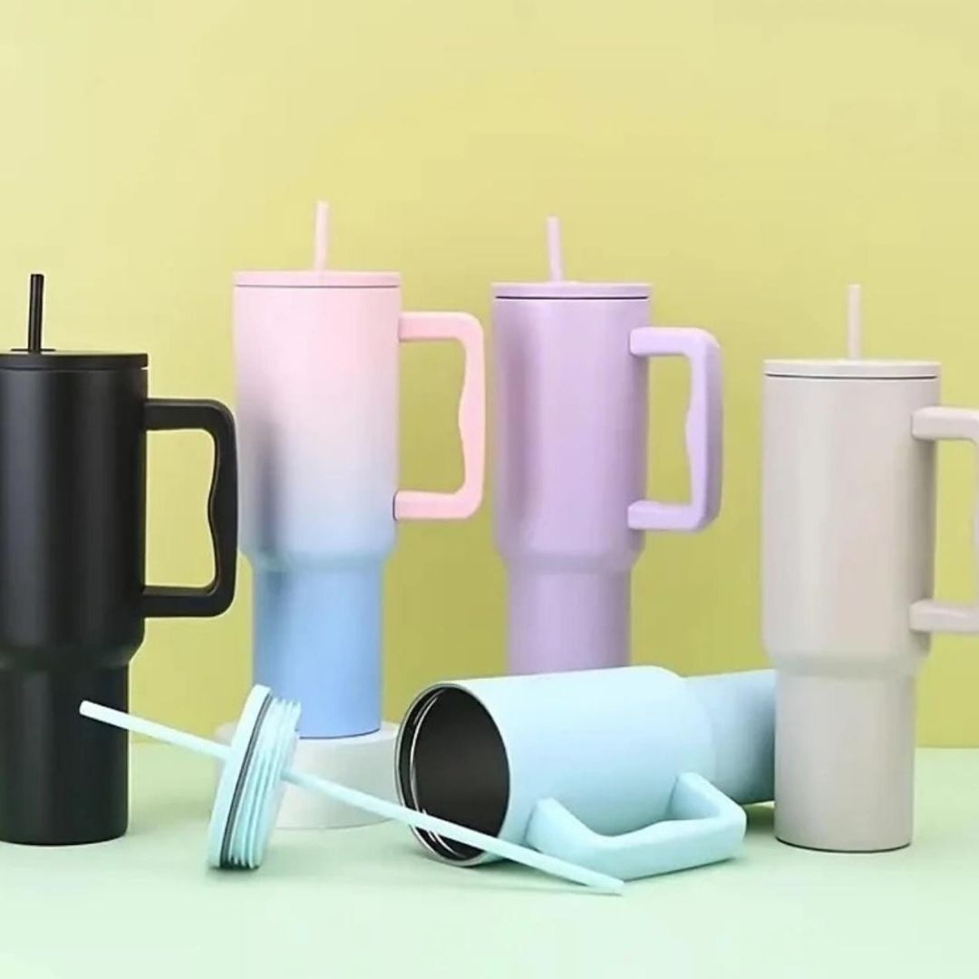 Set of colorful tumblers with handles on a light green background