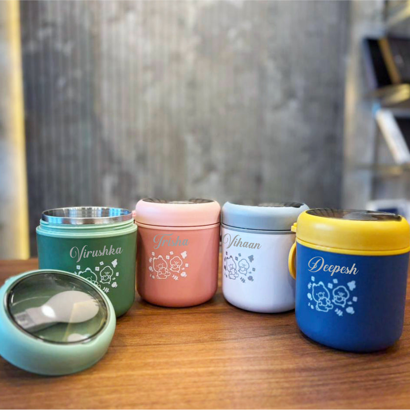 Set of colorful food containers with names on a wooden surface