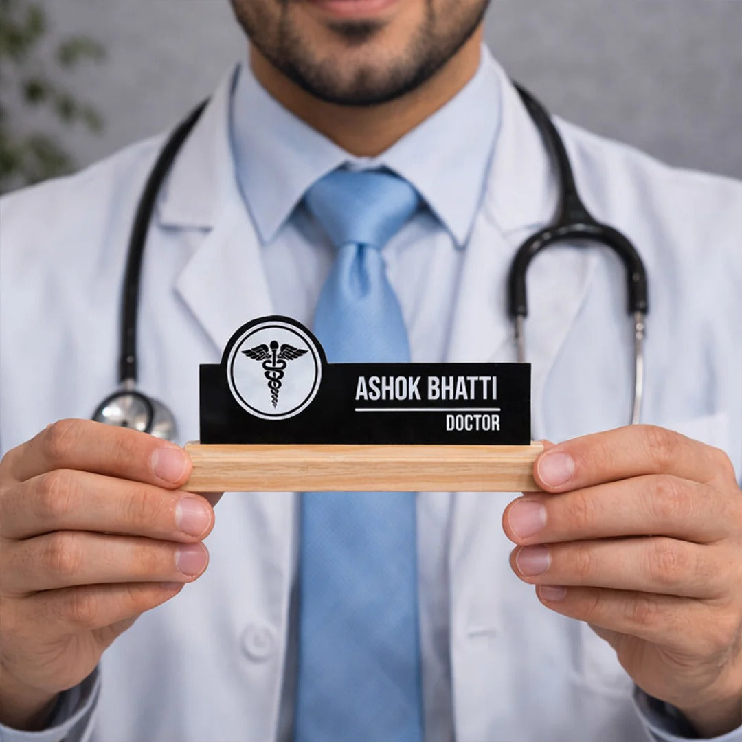 Doctor holding a nameplate with 'Ashok Bhatti, Doctor' against a neutral background
