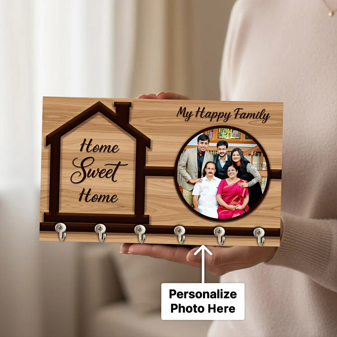 Wooden plaque with 'Home Sweet Home' and family photo, held by a person.