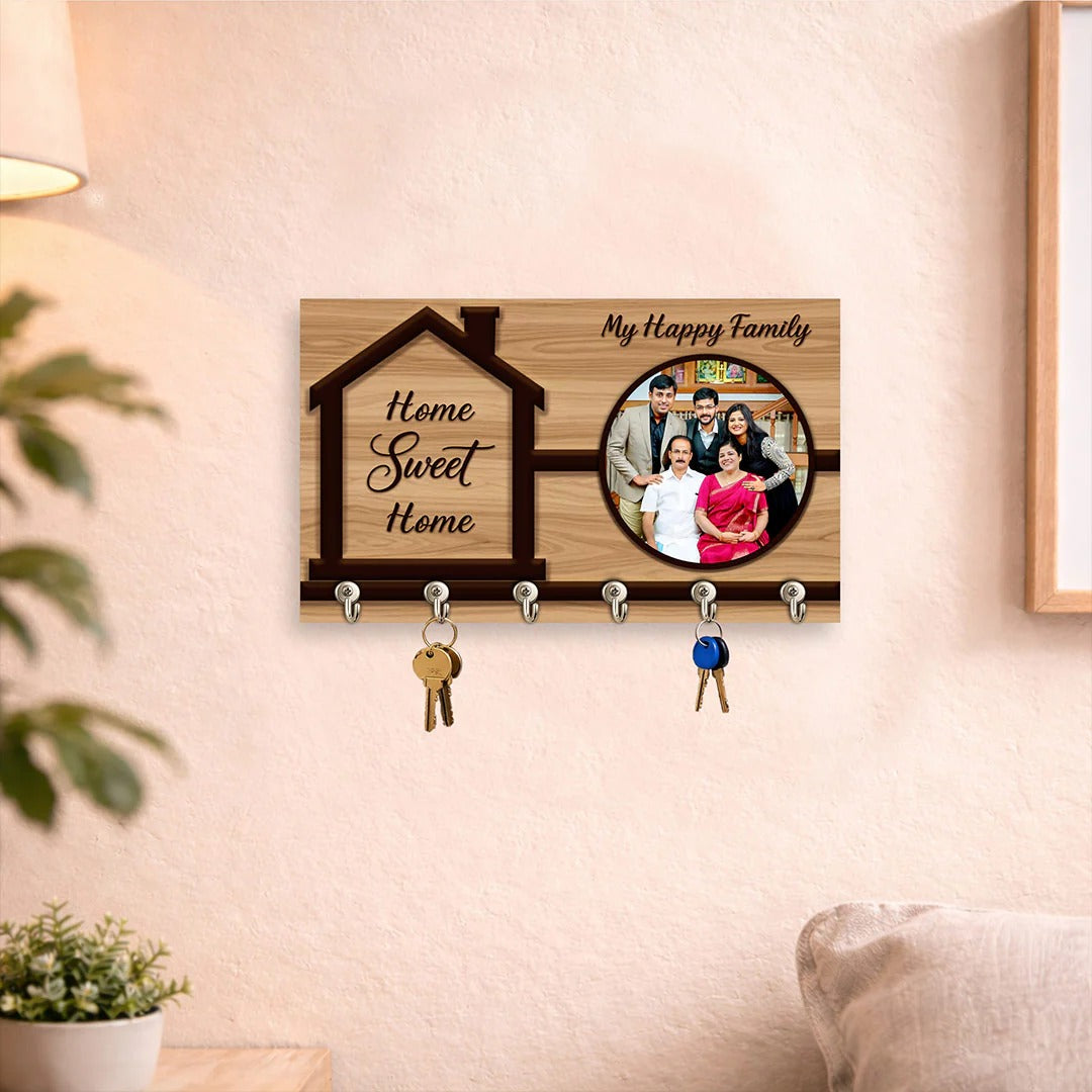 Wooden key holder with 'Home Sweet Home' and family photo on a wall.