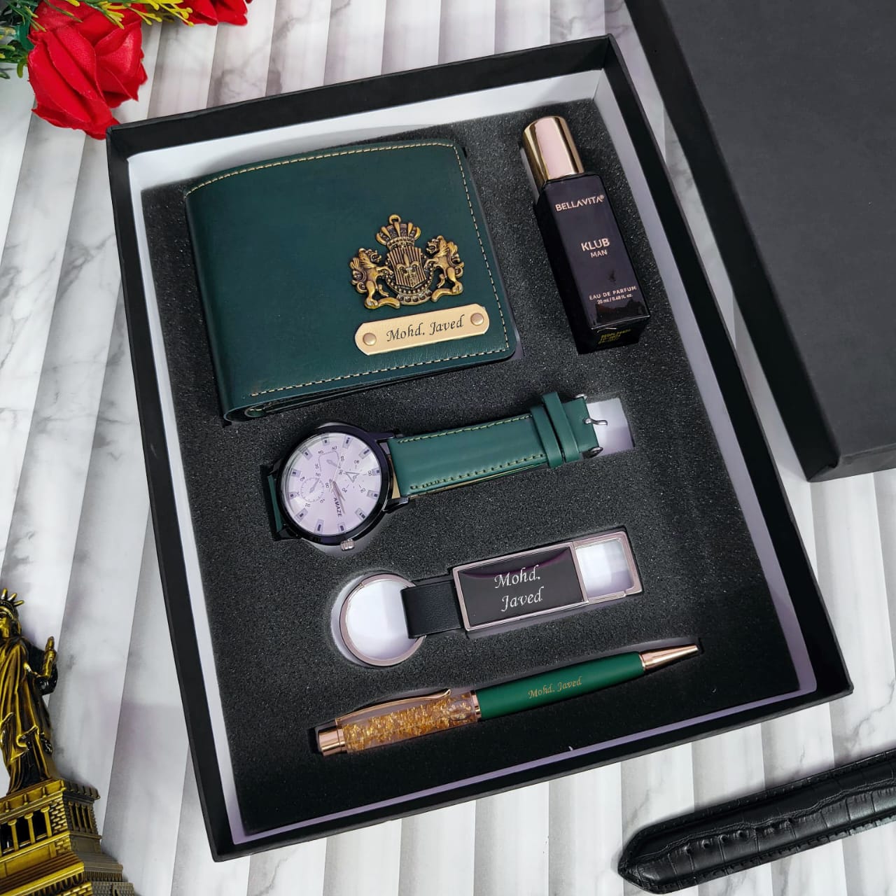 Gift set with green wallet, watch, pen, and other items in a black box.