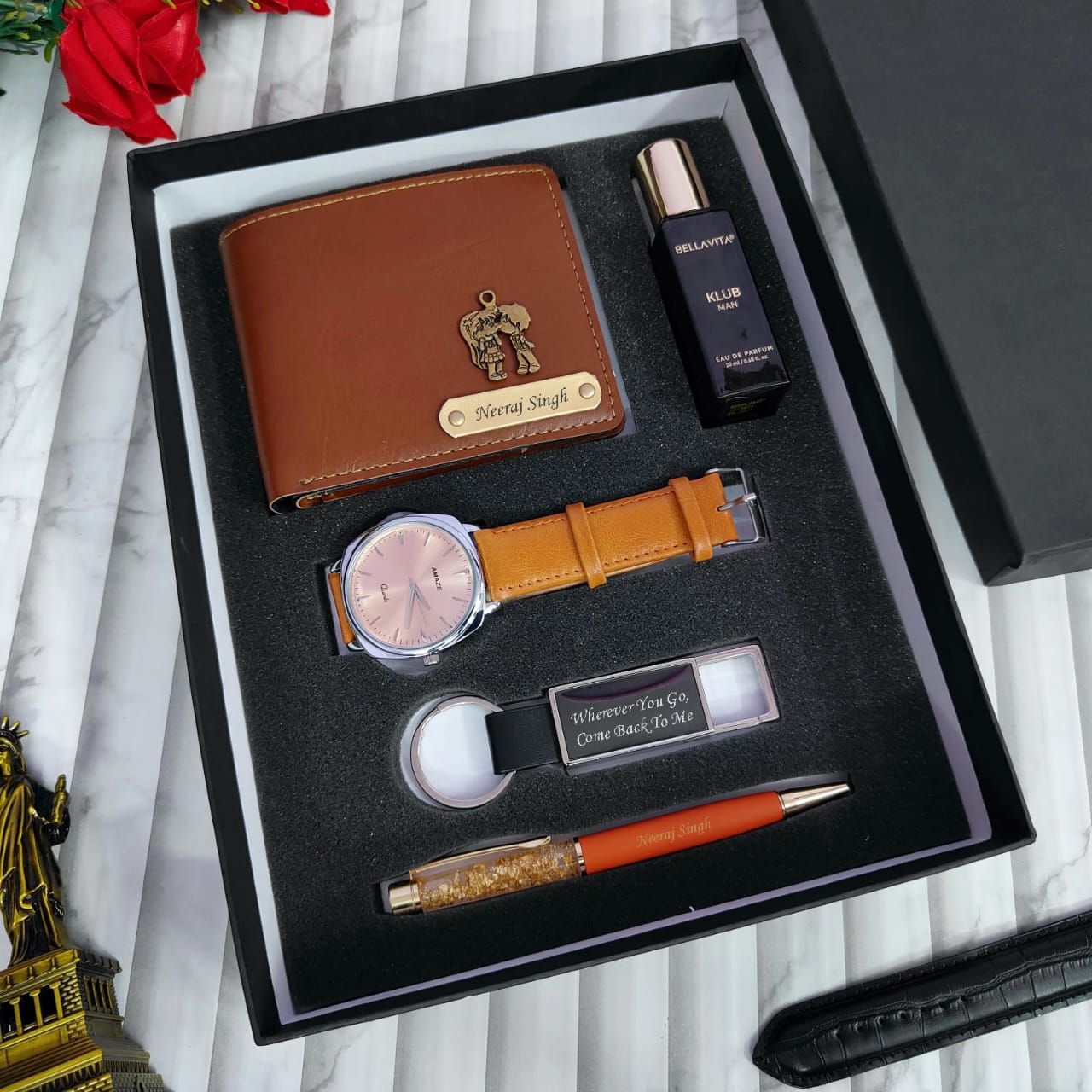 Gift set with leather wallet, watch, pen, and other items in a black box.