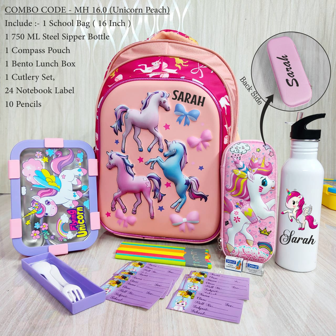 Pink unicorn-themed school supplies set with backpack, water bottle, and stationery items on a wooden surface.