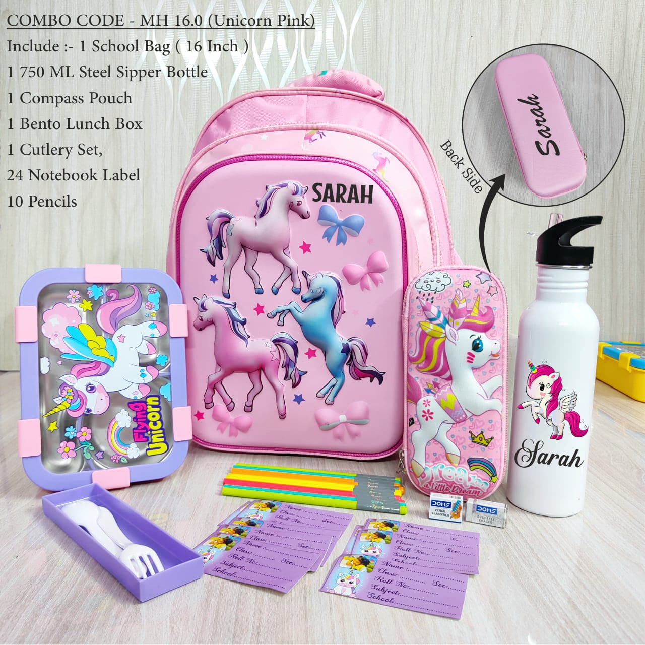 Pink school bag with unicorn design and stationery items on a wooden surface