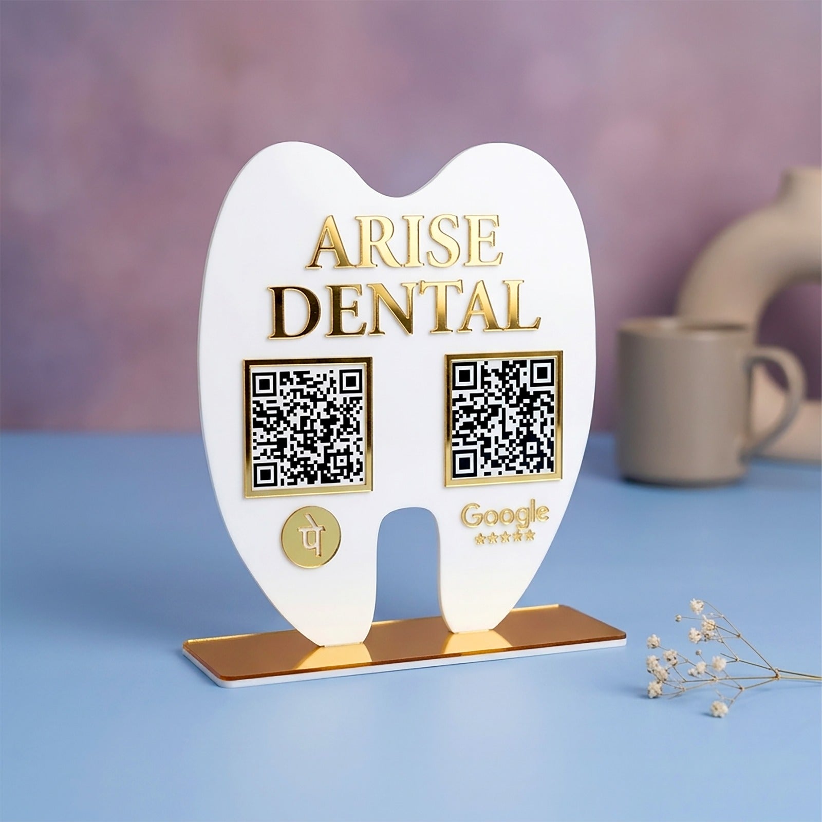 Heart-shaped stand with 'Arise Dental' branding and QR codes on a blue surface.
