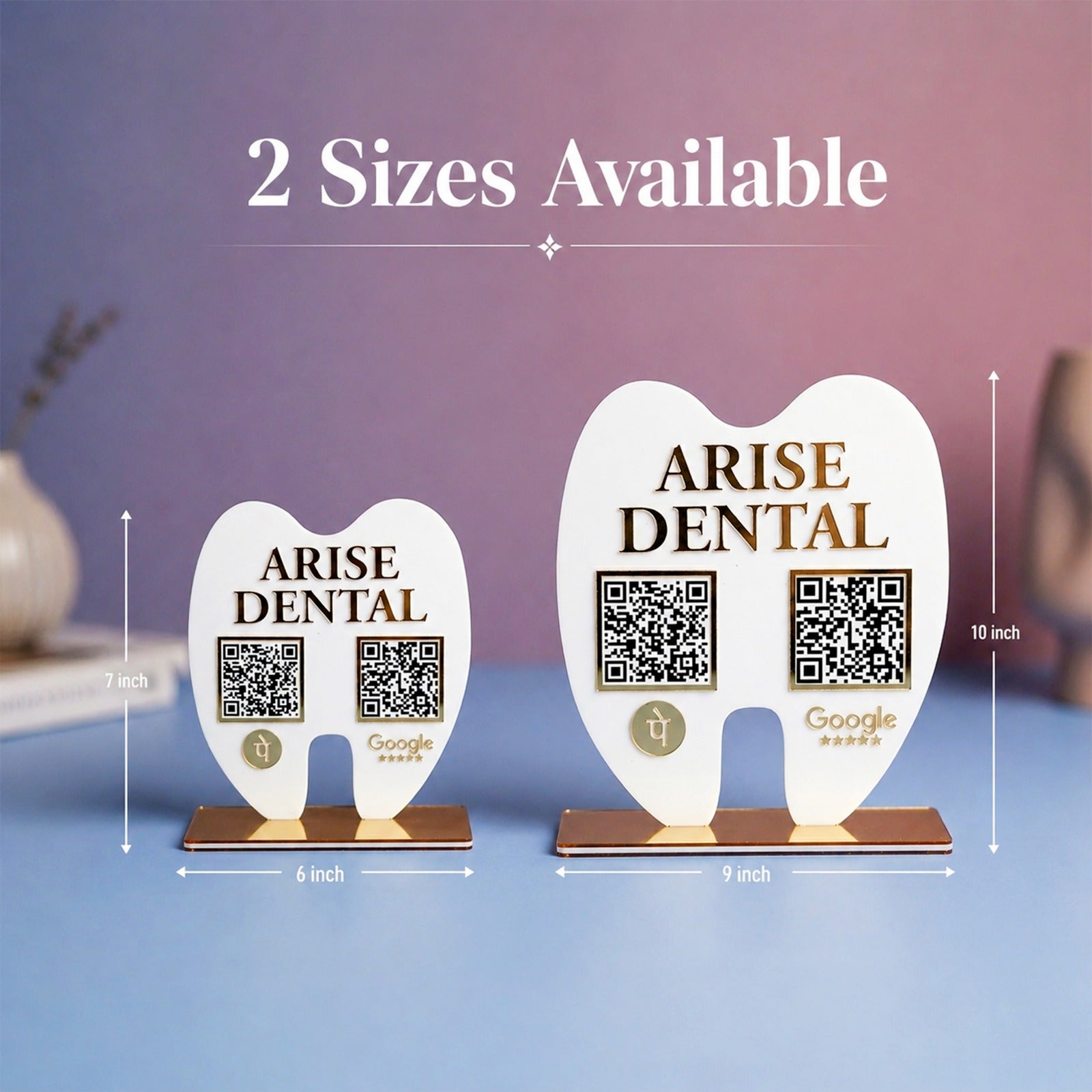 Two tooth-shaped 'Arise Dental' signs with QR codes on a blue surface.