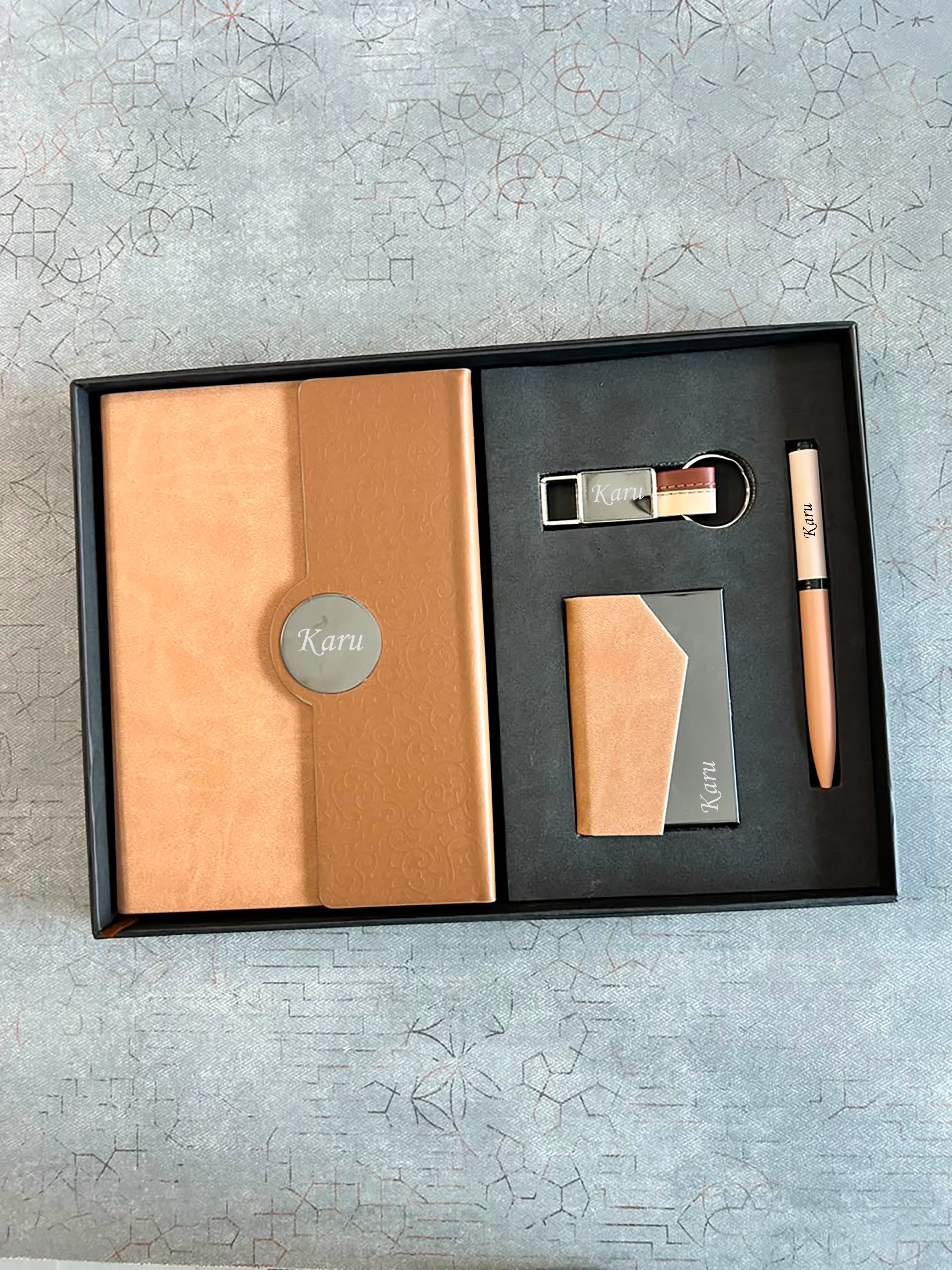 Gift set with a notebook, card, and pen on a textured surface