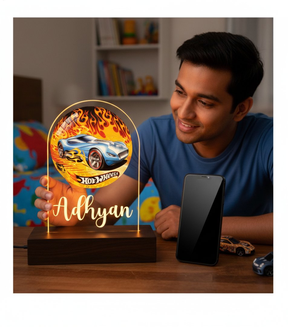 Man holding a Hot Wheels-themed lamp with 'Adhyan' on it, surrounded by toy cars and a colorful background.