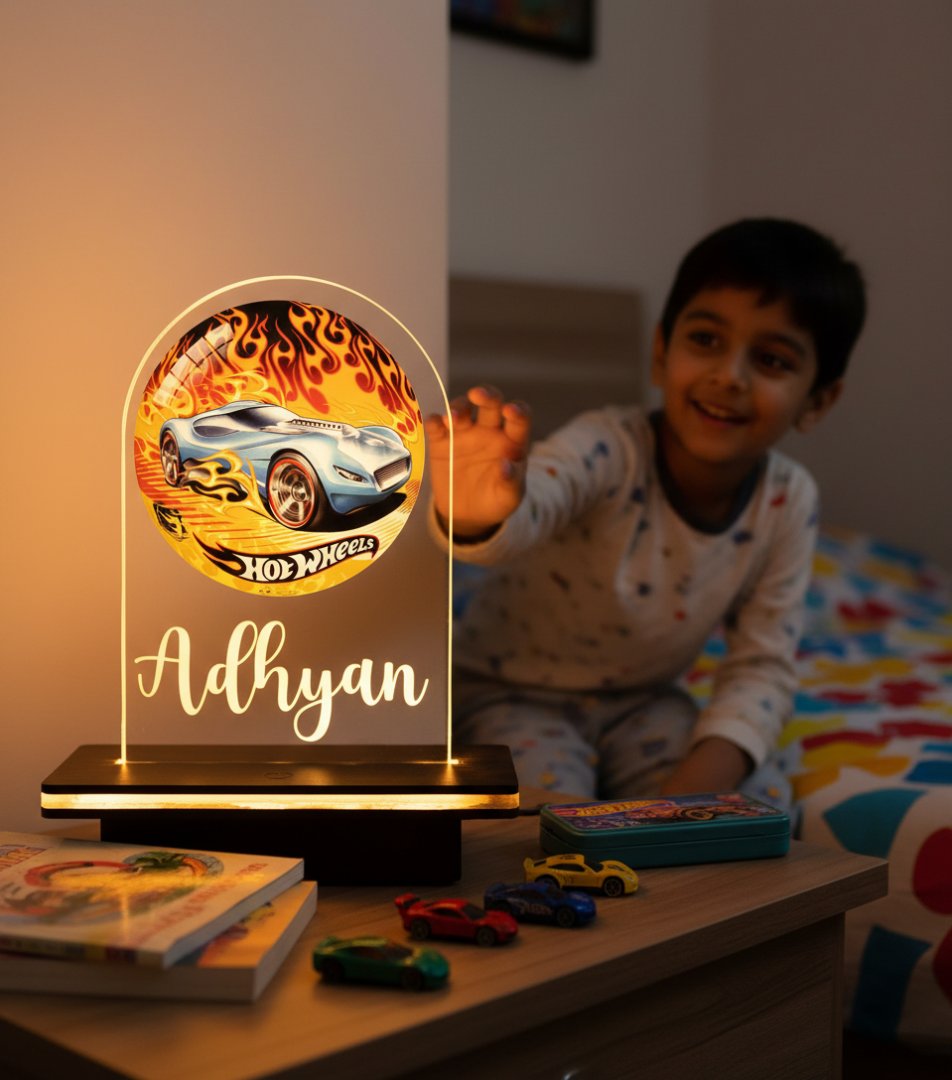 Child playing with toys next to a Hot Wheels-themed night light on a table.