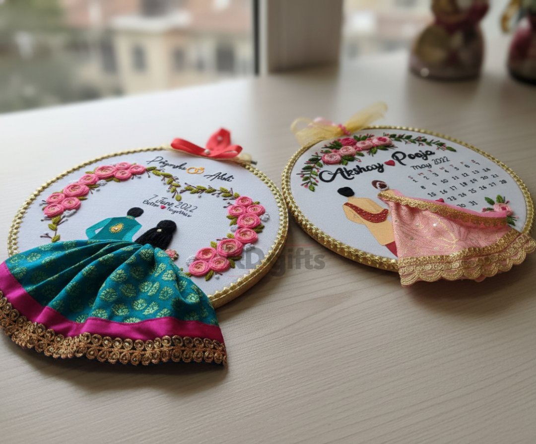 Two embroidered hoops with decorative designs on a table.