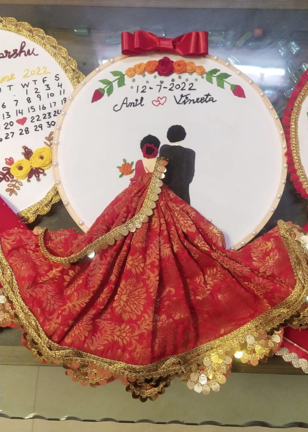 Decorative wall hanging with a couple illustration, date, and red fabric