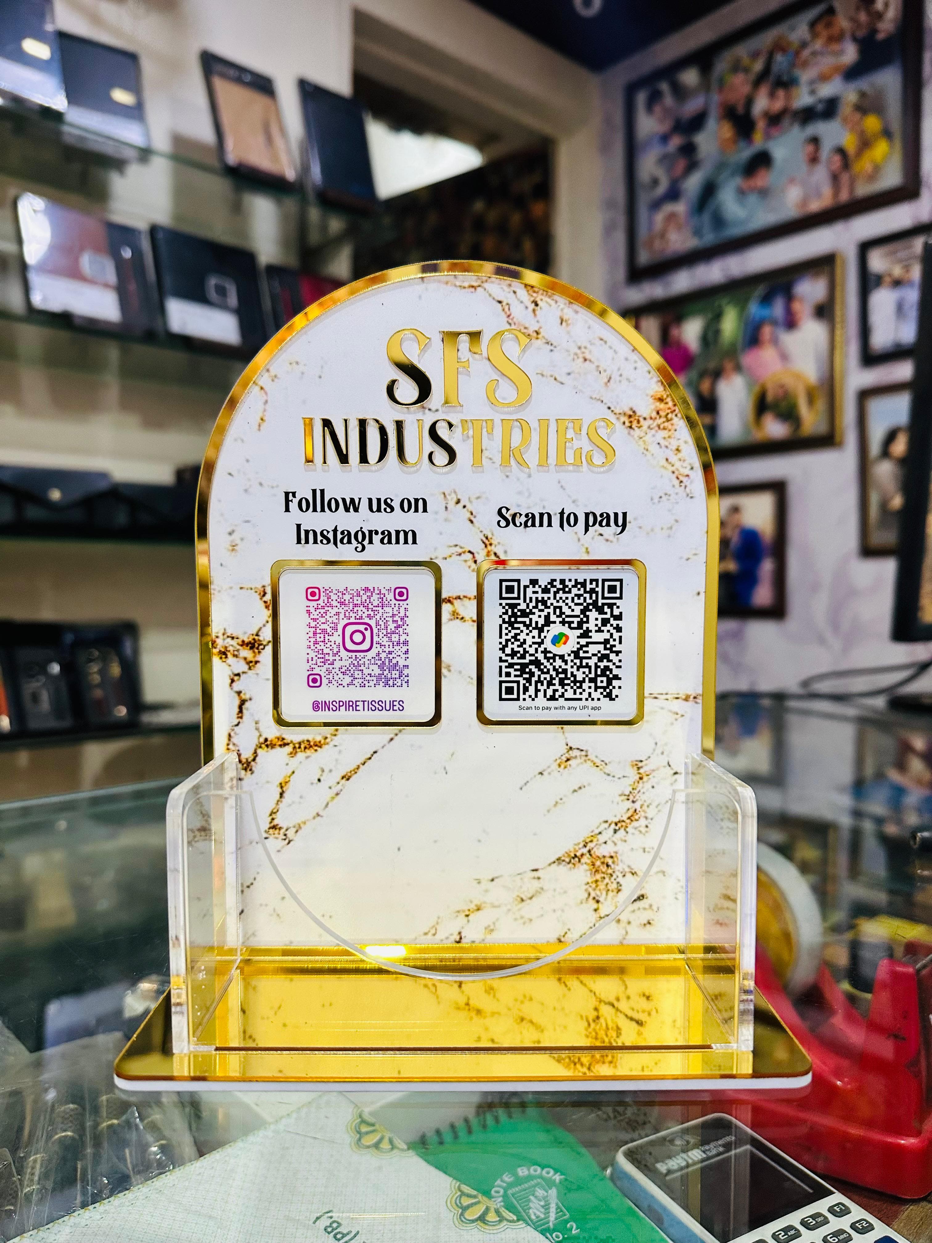 SFS Industries promotional stand with QR codes and contact information in a store setting.