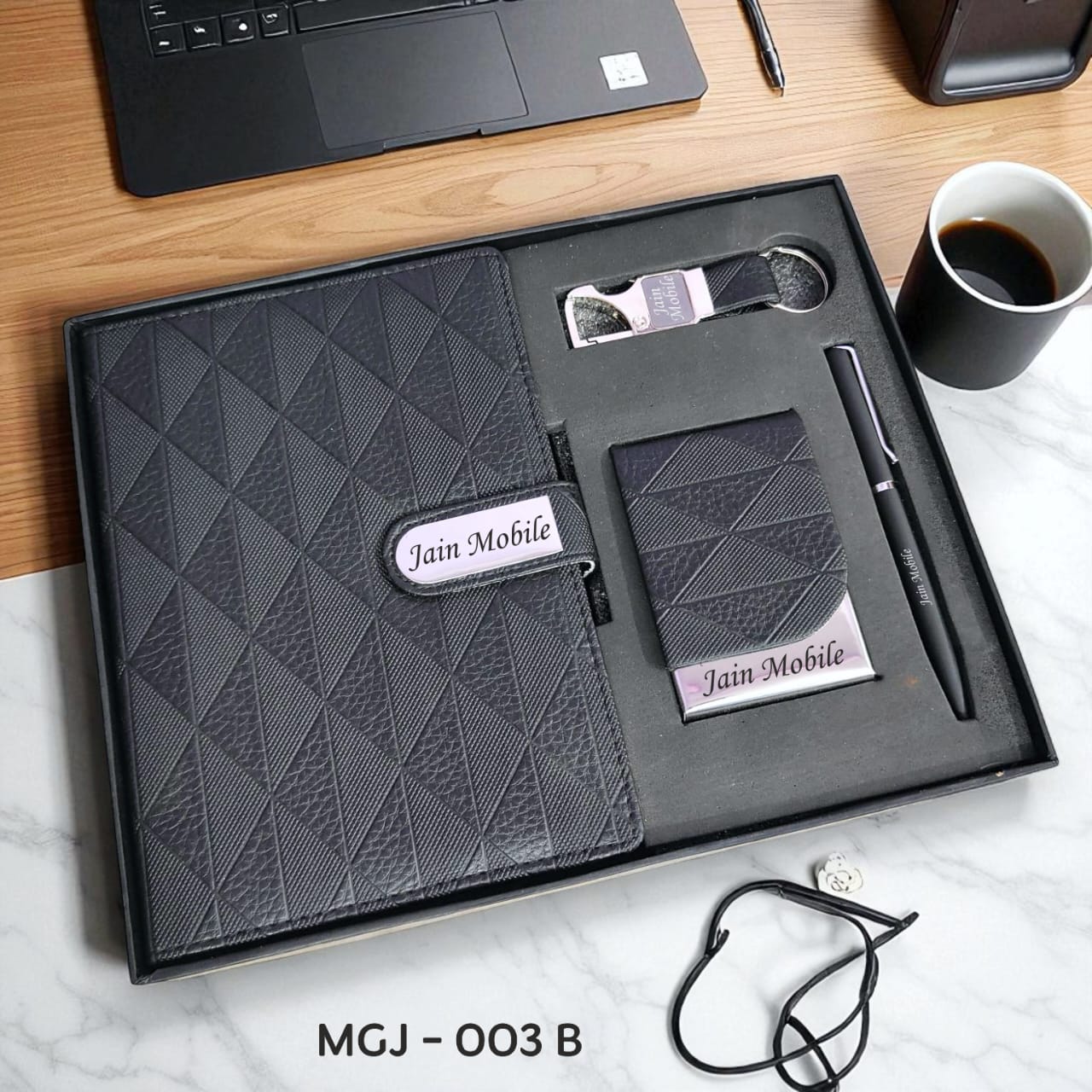 Jain Mobile product set including a notebook, pen, and other items in a black box on a desk.