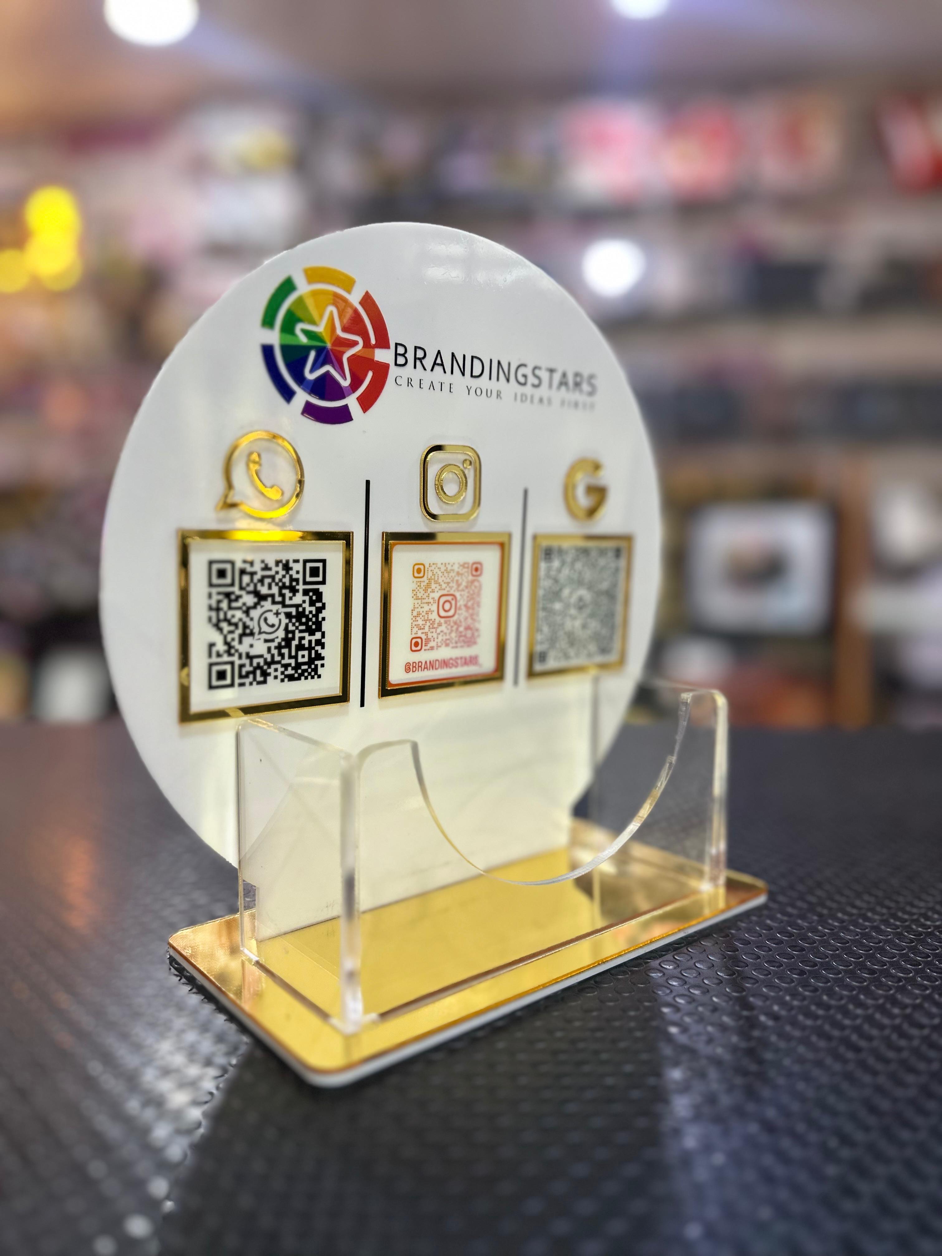 Round branding display with QR codes and logos on a stand, blurred background