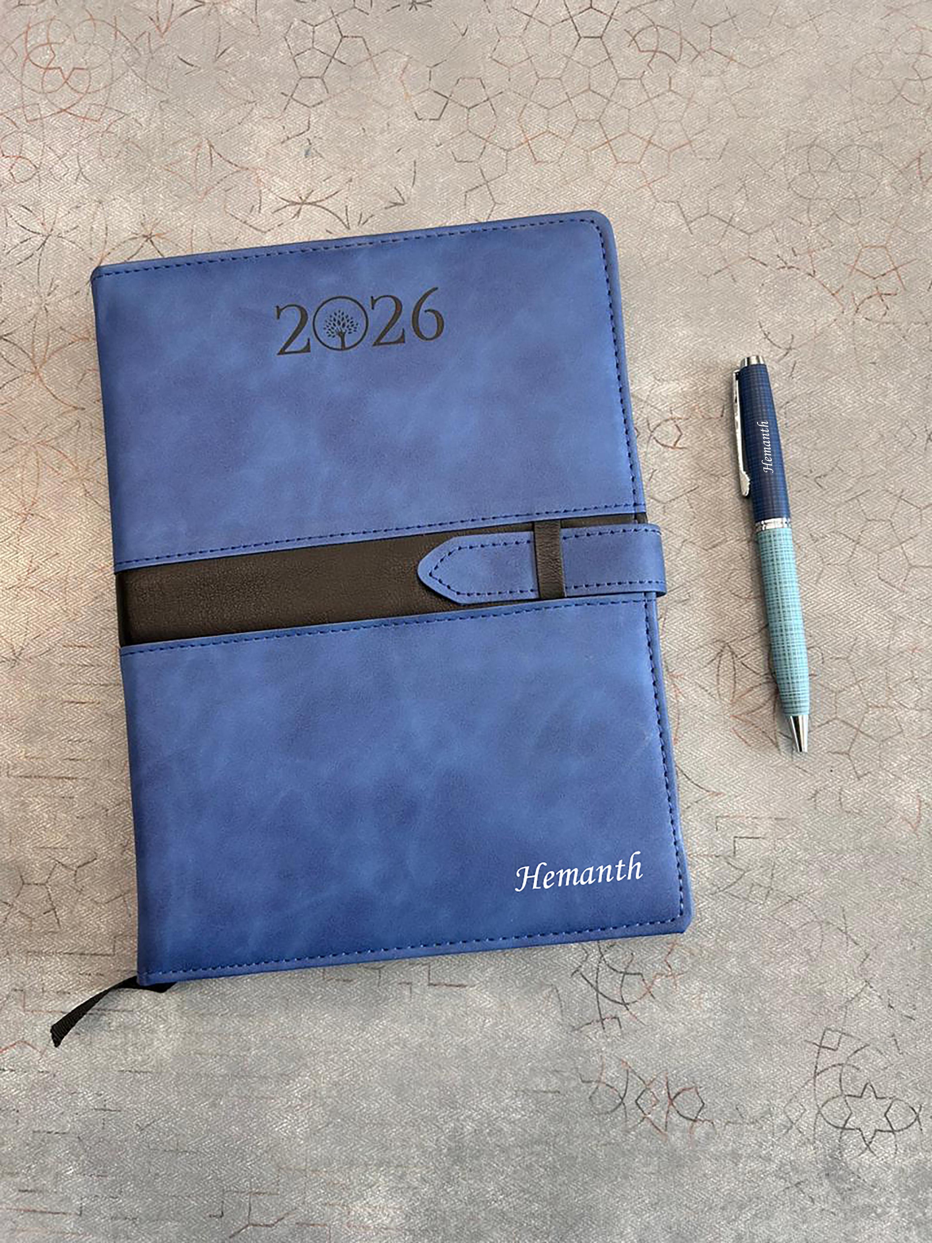 Blue planner with '2026' and 'Hemanth' branding on a textured surface