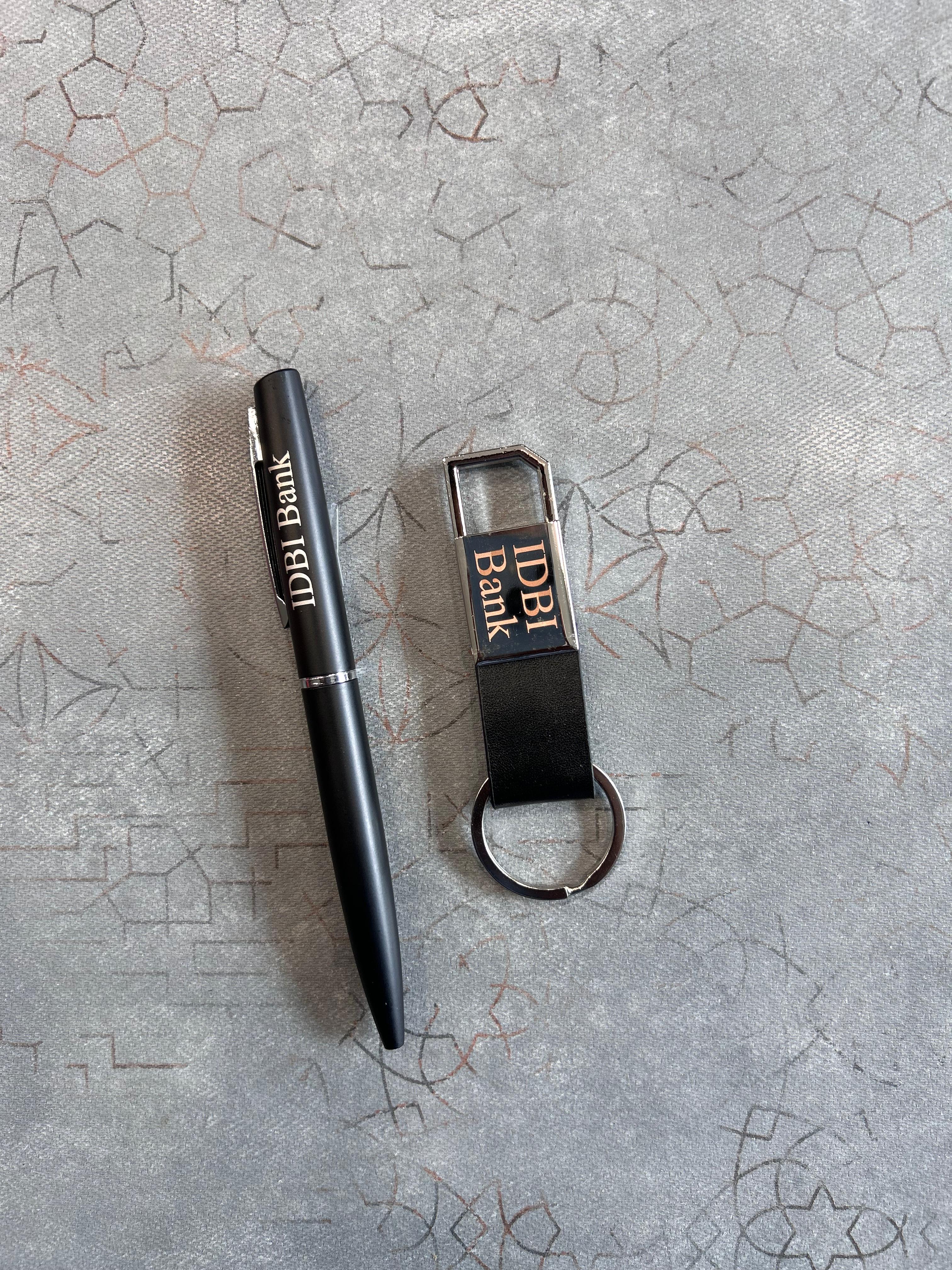 Black pen and keychain with 'IBank' branding on a textured gray surface