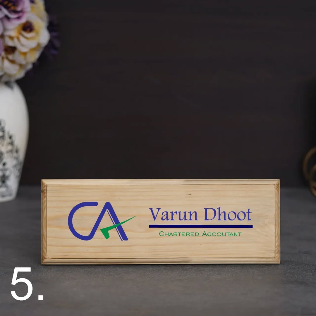 Wooden nameplate with 'Varun Dhoot Chartered Accountant' on a dark background
