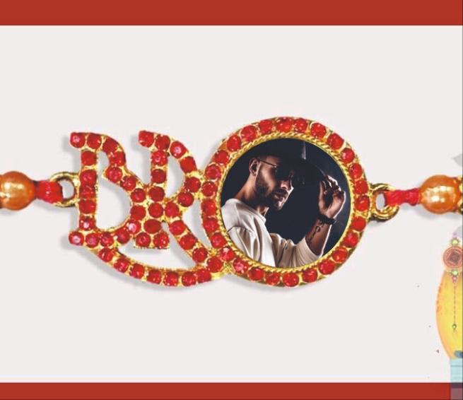 customized photo rakhi ,and bro is written with red colored stones and on letter 'o' photo placed.