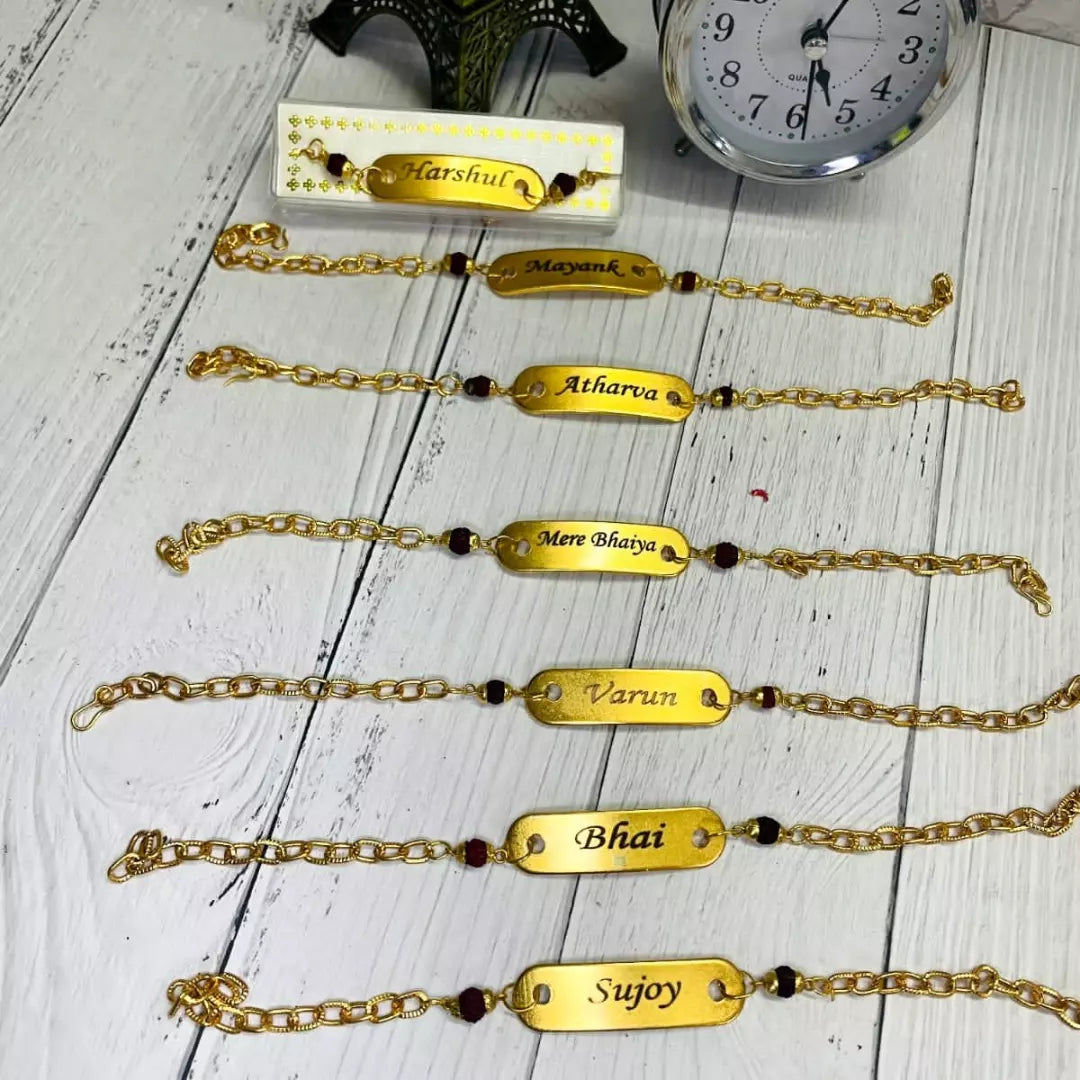 bracelet type chain rakhi with customize with your name it is in gold color, placed in wood background,7 rakhies are there