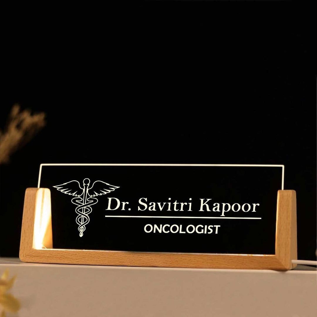 An LED illuminated desk name plate for an Oncologist, featuring a glossy finish acrylic plate with a wooden base.