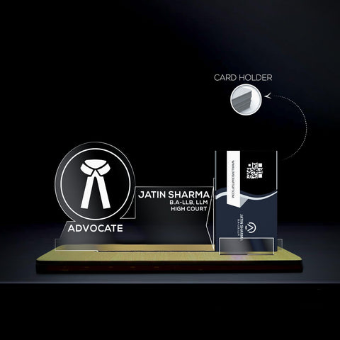 fully customized card holder stand ,A transparent acrylic nameplate with a wooden base, featuring the medical caduceus symbol and the word 'ADVOCATE' underneath it. The nameplate includes the name  with credentials  displayed next to the symbol. On the right side, there is a card holder containing a business card with a QR code and the website 