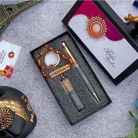Brother gift combo in box there is one customized grey pen and cutkey chain highquality rudraksh rakhi with name, beside box cap is there where greeting are written on it 