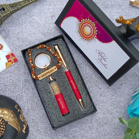 Brother gift combo in box there is one customized red pen and cutkey chain highquality rudraksh rakhi with name, beside box cap is there where greeting are written on it 