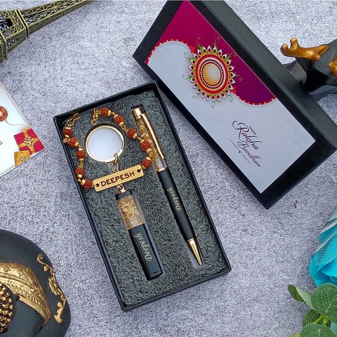 Brother gift combo in box there is one customized black pen and cutkey chain highquality rudraksh rakhi with name, beside box cap is there where greeting are written on it 