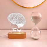 A decorative lamp featuring a detailed wireframe illustration of a human brain, illuminated from a wooden base. The lamp is labeled with the custom title "PSYCHOLOGIST" and the  custom name. It is placed on top of the book "Dear Universe" by Sarah Prout, creating a scholarly and sophisticated display.