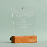 Customizable LED night light featuring a detailed caduceus symbol, personalized with the personalized name   and the any customized designation displayed on a wooden base with the option to add custom text at the bottom,it is looking without power 