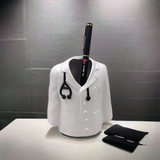 white ceramic apeon coat penstand with stethoscope on hanging neck and 1 balck pen is place inside of the penstand