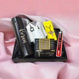 A gift set including a black thermos labeled custom name a pen with a medical symbol, a keychain with a stethoscope charm, a perpetual calendar with custom name inscribed, and a miniature doctor’s coat. The set is presented on a black tray with a pink fabric background.