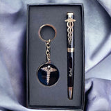 Elegant gift set featuring apersonalized  black pen with gold medical caduceus symbol and a matching keychain, displayed in a black box on a satin fabric background. Ideal for medical professionals. Product by BBD GIFTS