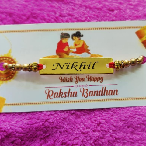 customized rakhi with name and its placed on pink color cloth