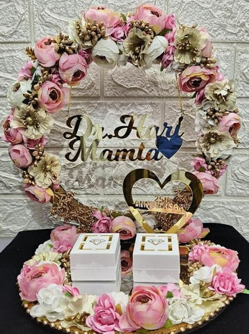 Decorative cake topper with flowers and 'Dr. Hari Mamid' text on a textured wall background
