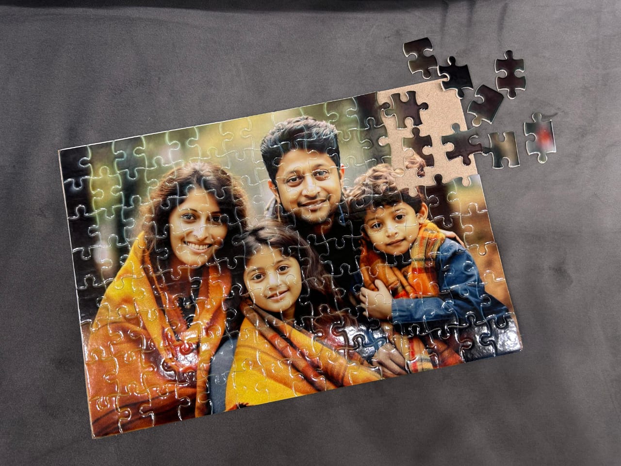 Jigsaw puzzle of a family photo on a gray surface