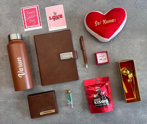 Collection of personalized items including a water bottle, notebook, heart-shaped pillow, and small gift boxes on a gray surface.