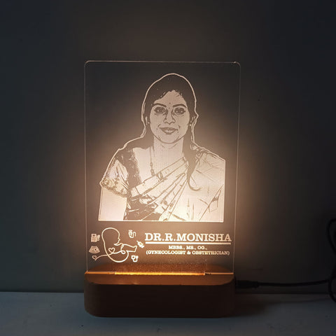 Lamp with engraved portrait and name on a dark background