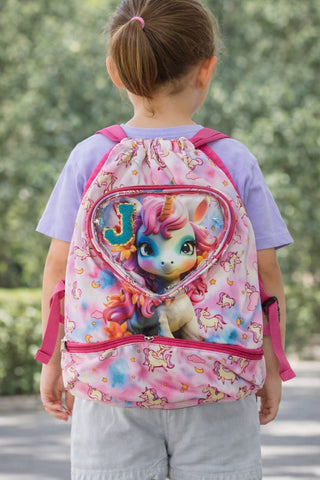 Child wearing a pink backpack with a cartoon character on a blurred green background