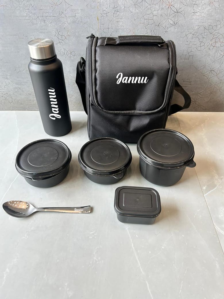 Black travel set with containers, a bottle, and a bag on a light surface.
