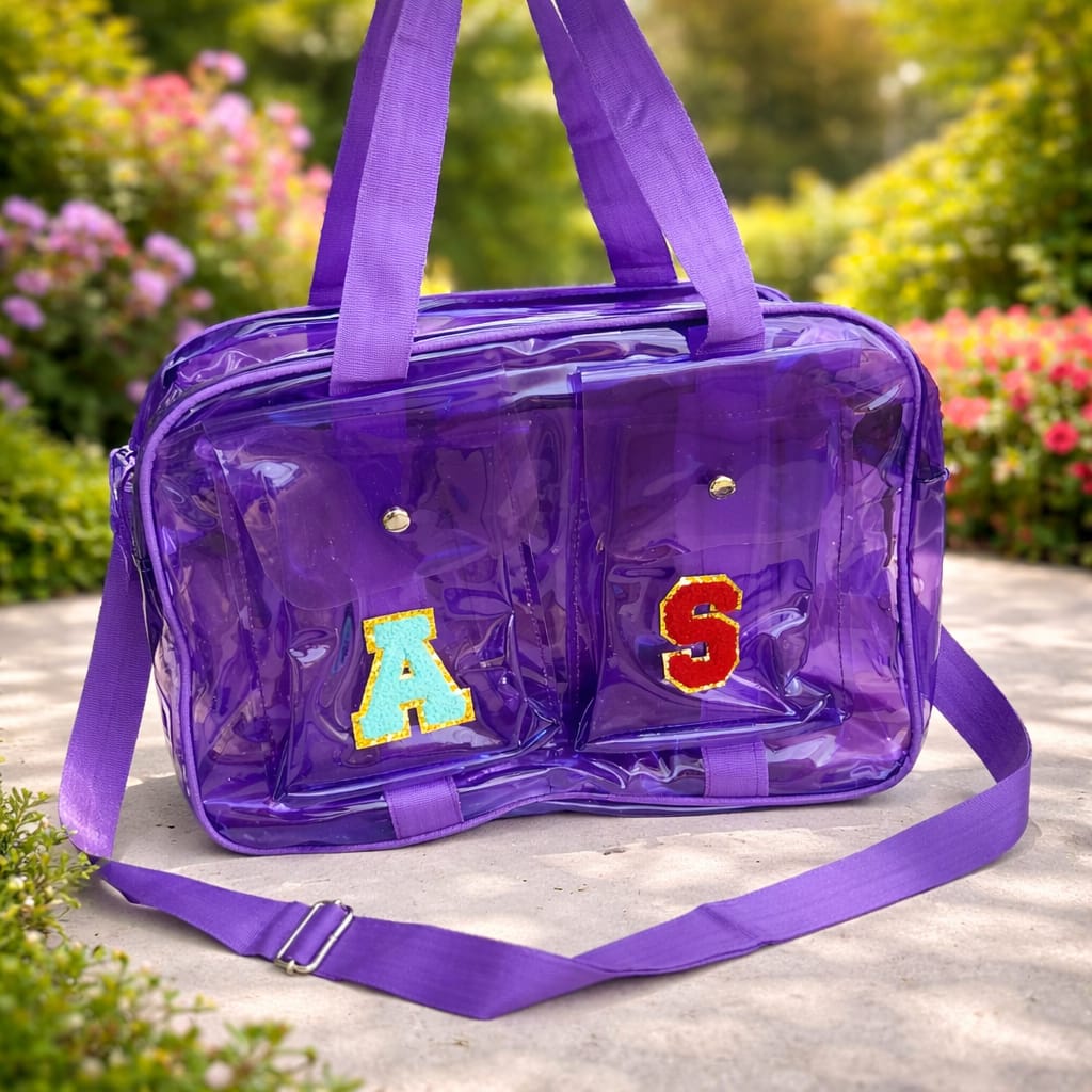 Purple transparent bag with letters 'A' and 'S' on a blurred natural background