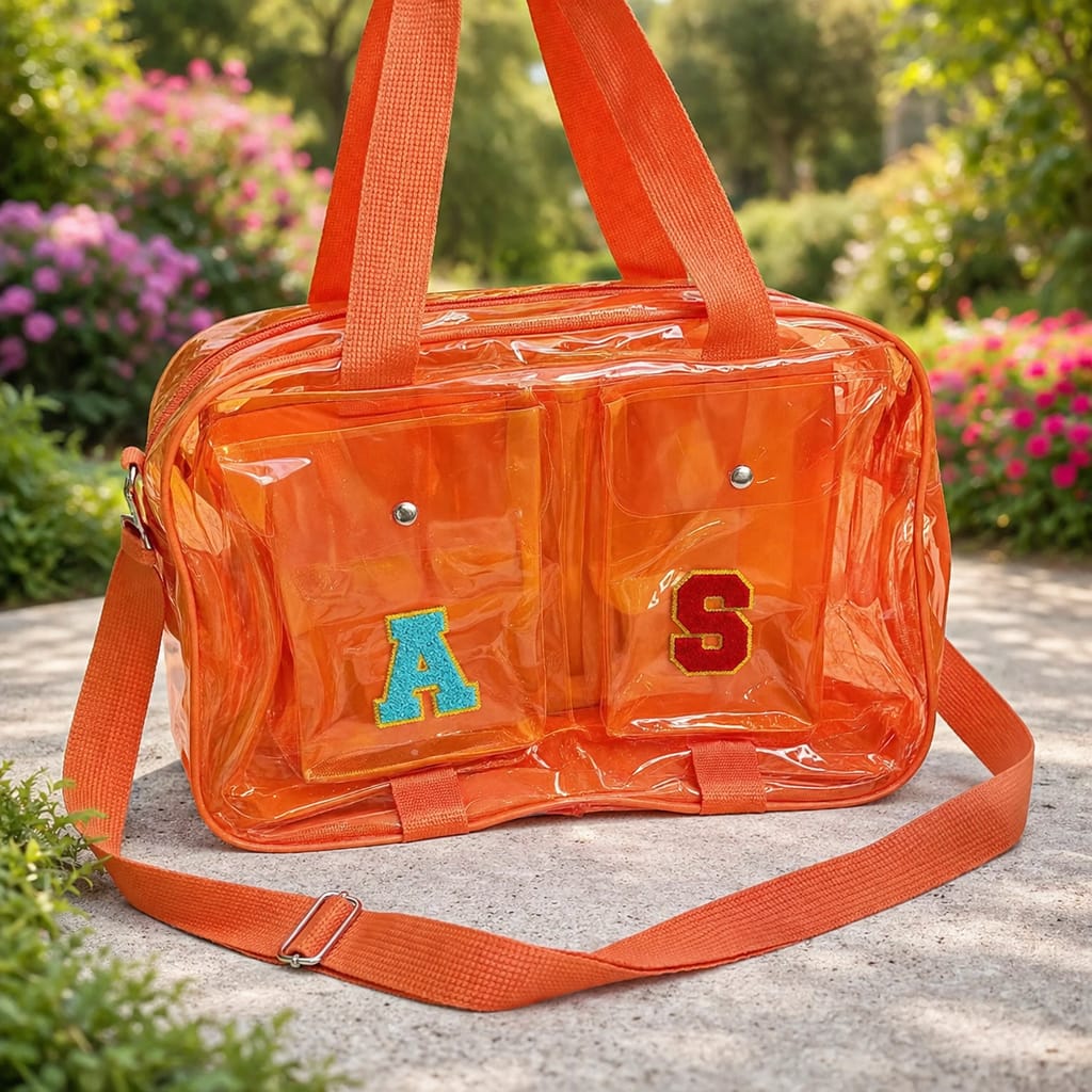 Orange transparent bag with letters 'A' and 'S' on a stone surface with greenery in the background