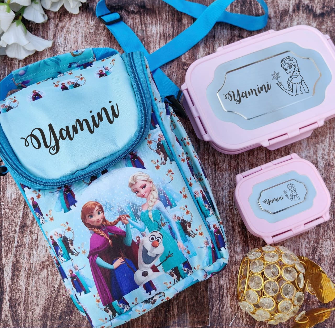 Frozen-themed lunch bag with 'Yamini' branding on a wooden surface