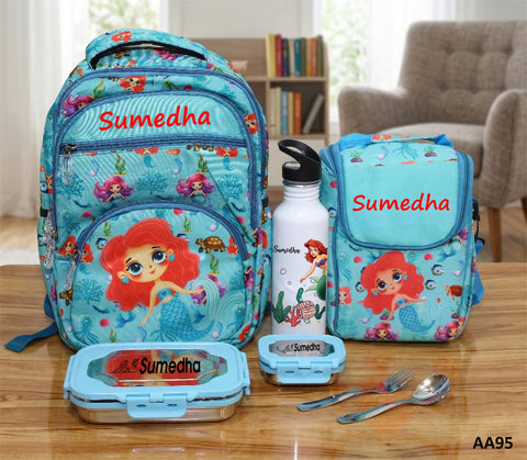 Mermaid-themed school backpack, lunch bag, water bottle, and utensils with 'Sumedha' branding on a wooden table.