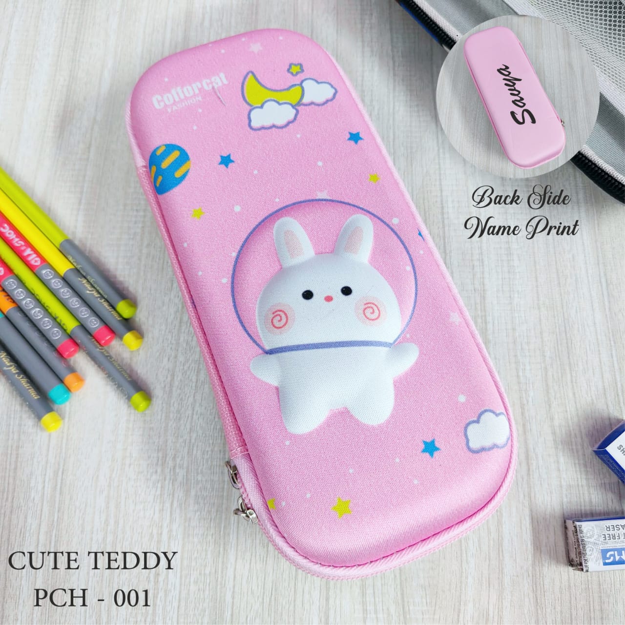 Pink pencil case with teddy bear design on a wooden surface with stationery items.