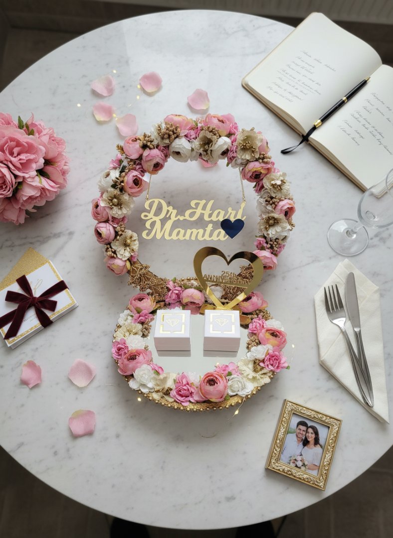 Decorative floral arrangement with 'Dr Hari Mama' on a marble table with flowers and a book.