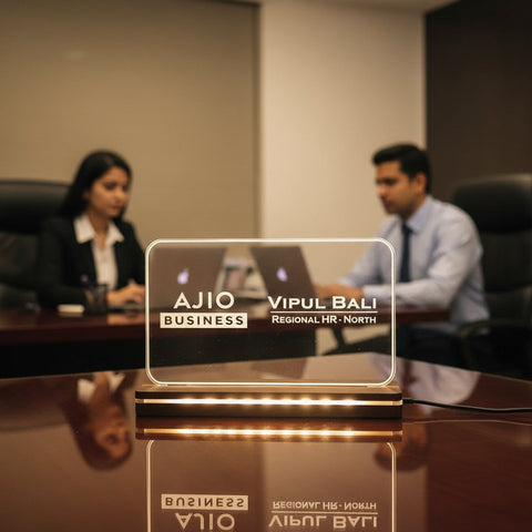 Clear nameplate with 'AJIO BUSINESS' and 'Vipul Bali' in a blurred office setting
