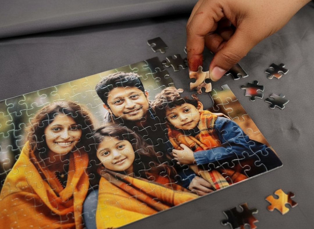 Hand completing a puzzle of a family photo on a gray surface